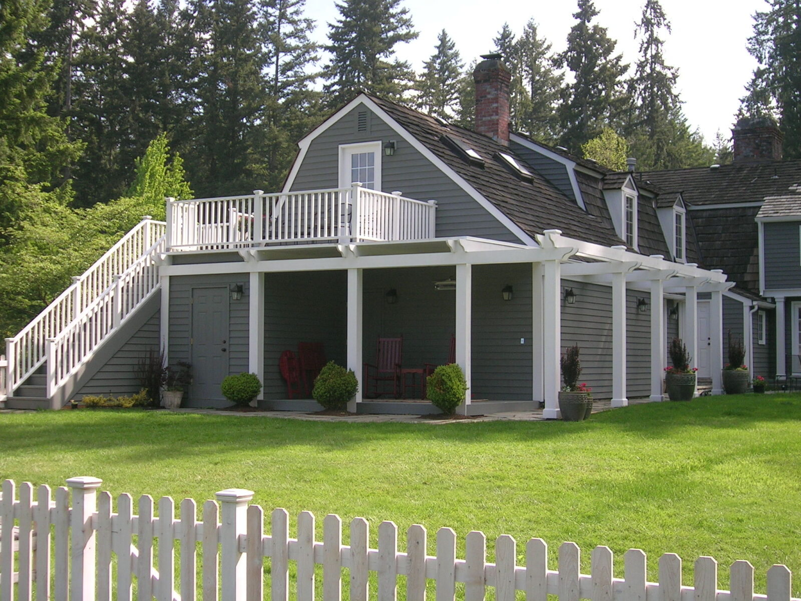 Large gray home with with deck on the back of the house