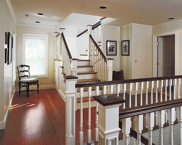 hallway with stairs to second level and stairs to basement